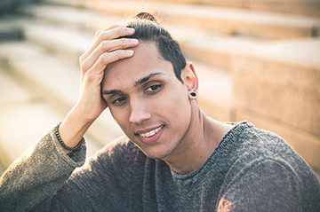 young man smiling and thinking